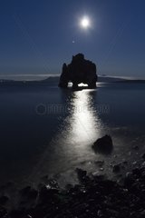 Reflection of the moon under the arch of basalt Hvítserkur Iceland