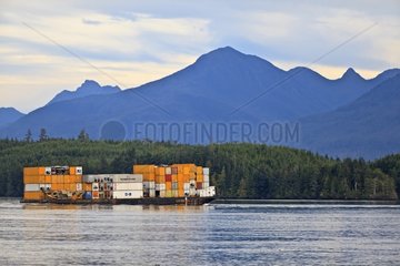 Barge carrying containers towed by a tug Canada