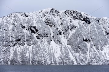 Snow-covered mountain on the coast of North Sea Norway