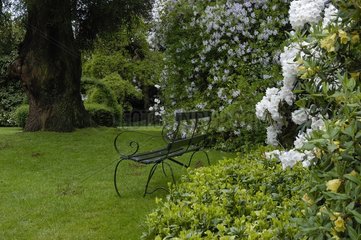Jardin anglais blanc avec banc en fer forgé