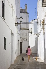 Woman walking her dogs on a street in Andalusia Spain