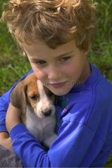 Garçon de 7 ans enlaçant tendrement un chiot de race Beagle