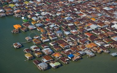 Homes built on stilts on edge of river Sungai Kinabatangan