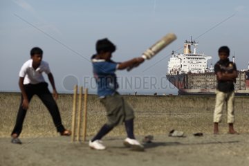 Boys playing cricket near a demolition site Bangladesh