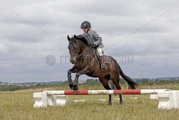 Young girl horse jumping competition North Cotswolds UK