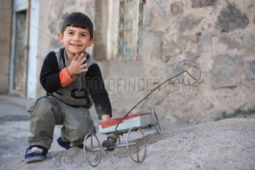 Child playing with a truck built by his grandfather