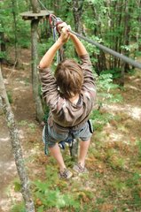 Boy on rope bridge in a tree climbing France