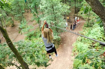 Girl on rope bridge in a tree climbing France