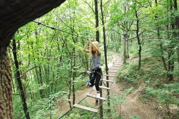 Girl on a suspension bridge in tree climbing France