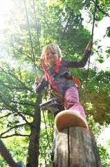 Girl on a wooden pole tree climbing France