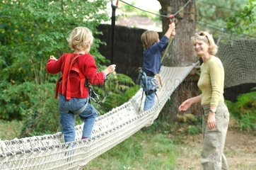 Children on rope bridge in a tree climbing France