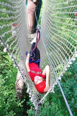 Girl lying in a net in a tree climbing France