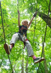 Girl on rope bridge in a tree climbing