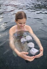 Young woman and pumice stone floating in the sea Lipari