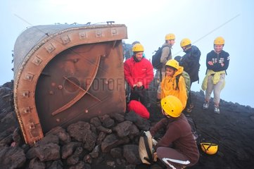 Tourists behind a shelter at summit of Stromboli volcano