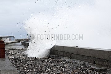 Wave throwing pebbles on the pier Hight tide France