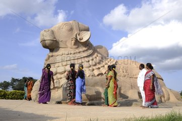 Women in saris in front of the statue of the god Nandi India