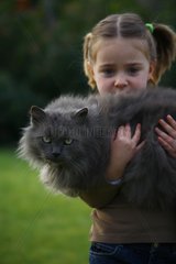 Child holding a cat in her arms