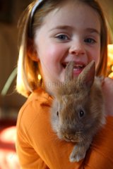 Child holding a young rabbit in her arms