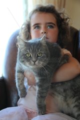 Girl holding a cat in her arms