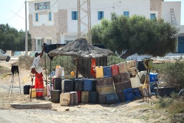 Man selling Libyan gasoline in cans Djerba Tunisia