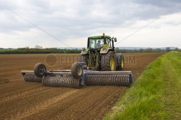 Tractor rolling on a field at spring GB
