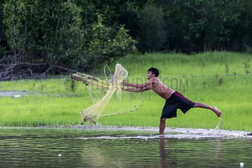 Fisherman throwing his net into the Rio Negro Brazil