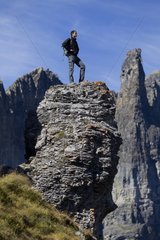 Hiker on rocky peak Valais Alps Switzerland