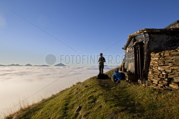 Hiker and sea of clouds Valais Alps Switzerland