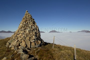 Cairn in front of a sea of fog Valais Alps Switzerland