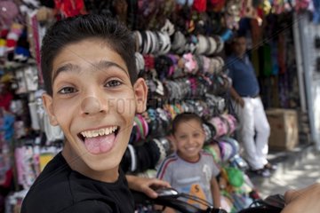 Boy sticking his tongue out at a shop Shiraz Iran