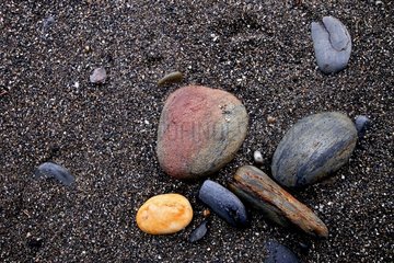 Rounded pebbles by the sea on a black sand beach