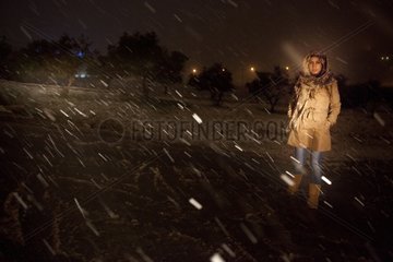 Young woman at night in a snowstorm in Jordan