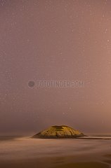 Beach and rock under the stars on the Cantabrian sea Spain