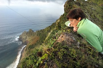 Young woman on the cliffs of the island Corvo Azores Portugal