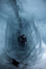 Scuba diver inside a cave ice Lake Sassolo Switzerland