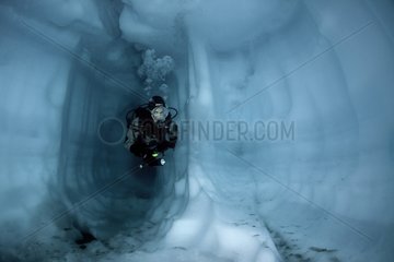 Scuba diver inside a cave ice Lake Sassolo Switzerland