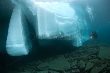 Scuba diver watching an ice formation in the Lake Sassolo