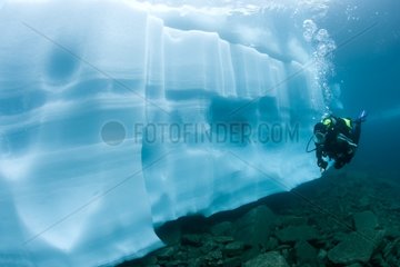 Scuba diver watching an ice formation in the Lake Sassolo