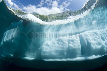 Ice wall from underwater with mountains on background