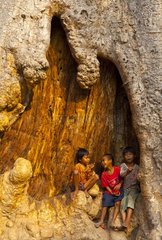 Children in a trunk at Ta Phrom Temple at Angkor in Cambodia