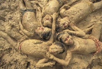 Jeunes indiens Mayoruna allongés dans la boue Pérou
