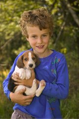 Garçon de 7 ans portant un chiot de race Beagle USA