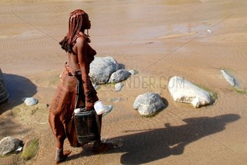 Himba woman providing fetching water in Namibia