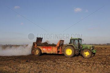 Tractor spreading muck in winter