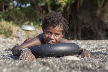 Boy playing on a black sand beach - Vanuatu