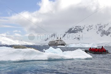 Tourists raft near an iceberg Antarctica