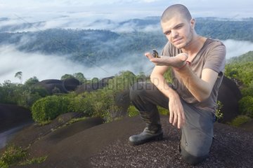 Herpetologist and Poison Frog on inselberg - French Guiana