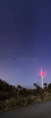 Many constellations over a wind turbine
