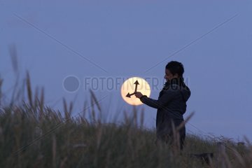 Person using the full moon as a clock